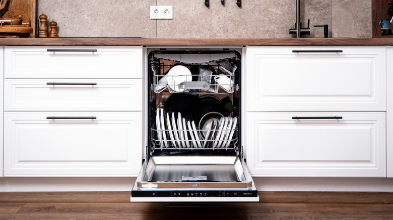 View of a full, open dishwasher in a kitchen