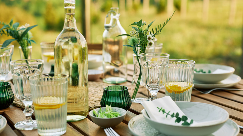 A table fully set outdoors with water glasses
