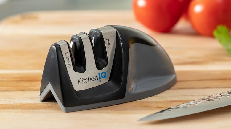 The KitchenIQ sharpener on a cutting board with a knife nearby