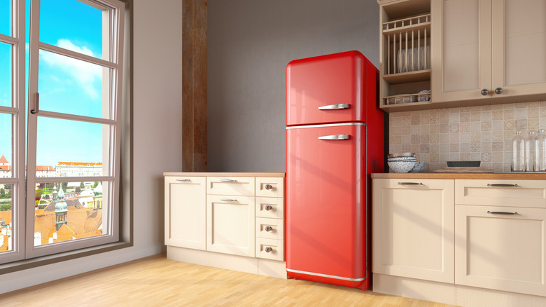 Retro red fridge in kitchen with large window