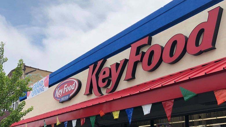 Exterior of a Key Food store with a grand opening banner
