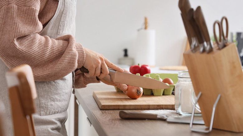 woman cutting onion with knife