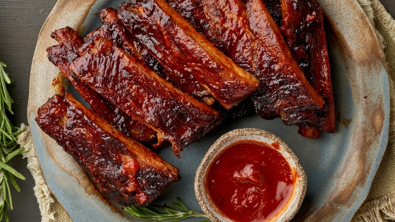 cooked individual ribs with a dipping sauce and coated in marinade