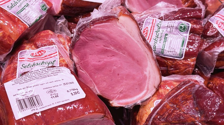 Vacuum packed hams in a pile with grocery labels