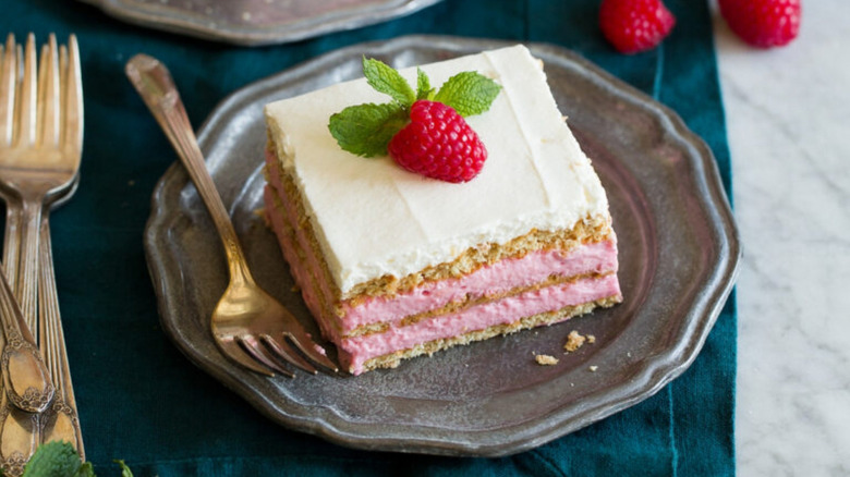 Raspberry icebox cake on an antique pewter plate garnished with a fresh raspberry and mint
