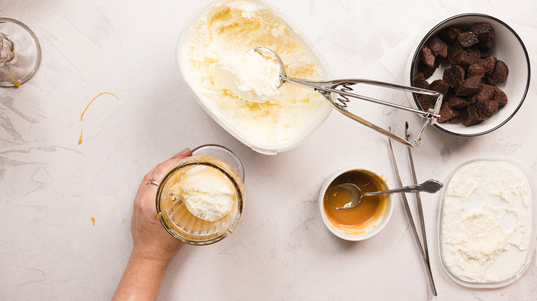 Adding ice cream to glass with caramel