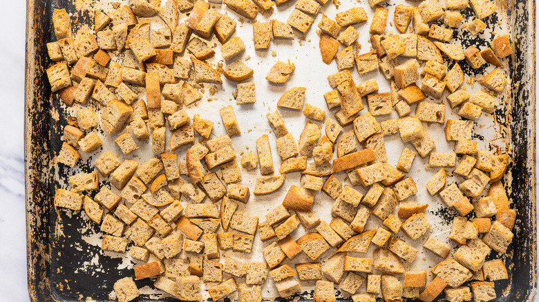 Toasted cubed bread on baking sheet.
