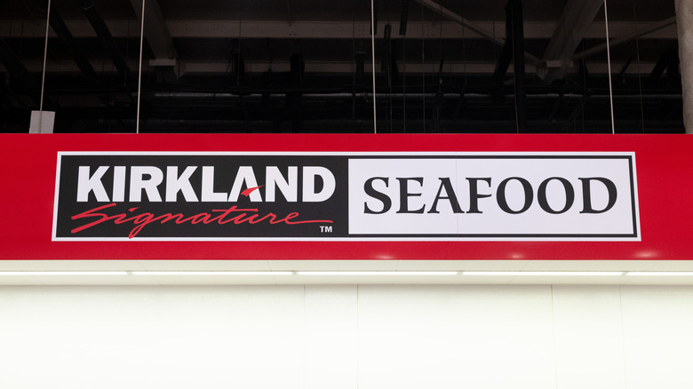 Red banner inside Costco store reading 'Kirkland Signature seafood'