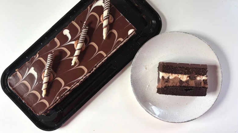 A chocolate cake with a slice on a plate