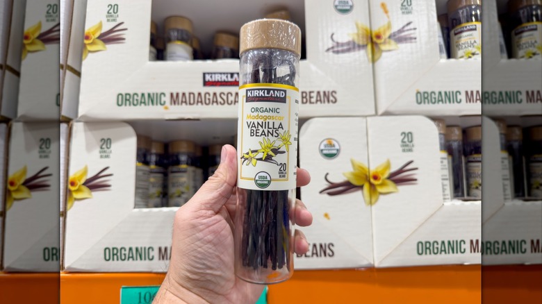 Hand holding a jar of Kirkland Signature Organic Madagascar Vanilla Beans at Costco