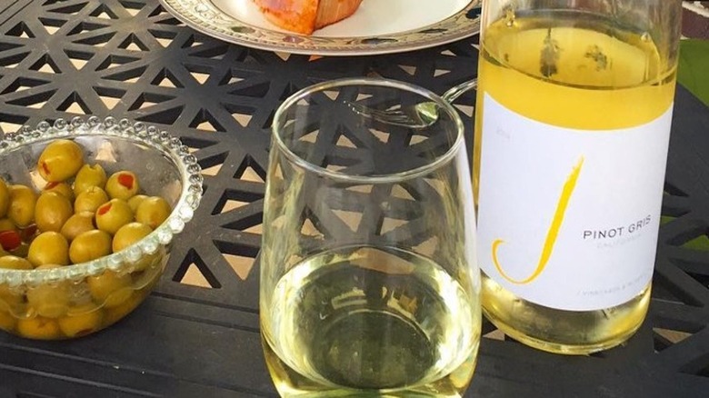 Bottle of J pinot gris with glass and olives