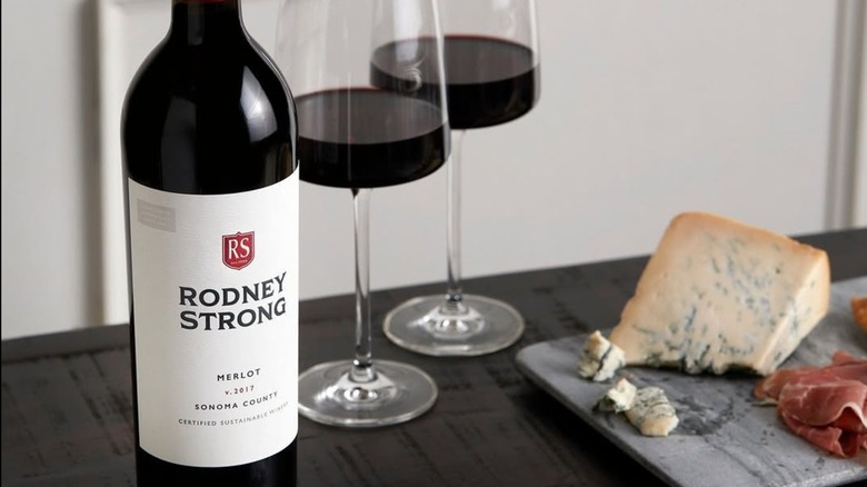 Bottle of Rodney Strong merlot with glasses and blue cheese