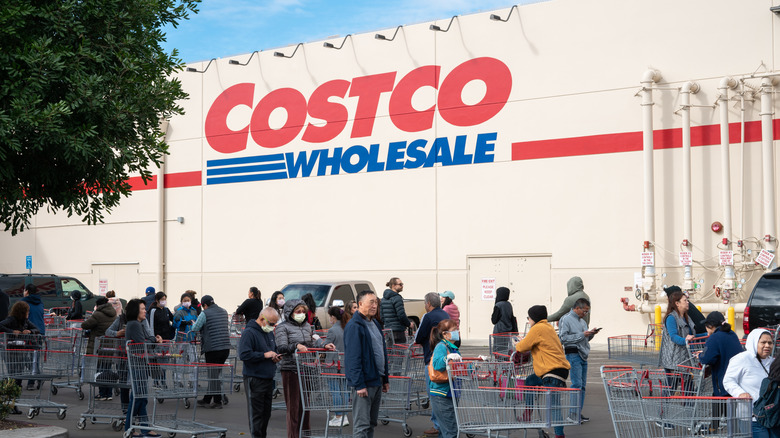 Line of customers with carts standing outside Costco Wholesale store in Alhambra, California