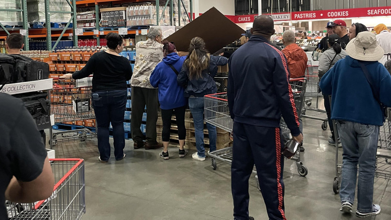 Crowded area inside Monterey Park, California Costco store with customers with carts inspecting products