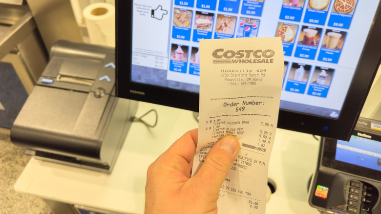 Hand holding receipt from Costco food court inside location in Roseville, California