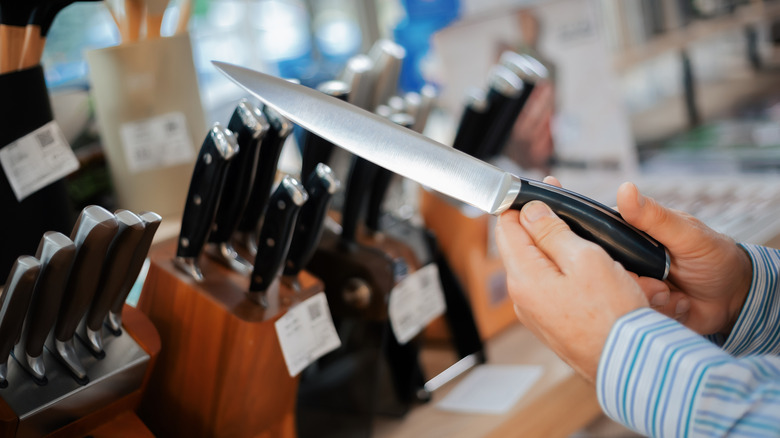 person shopping for knife set in store
