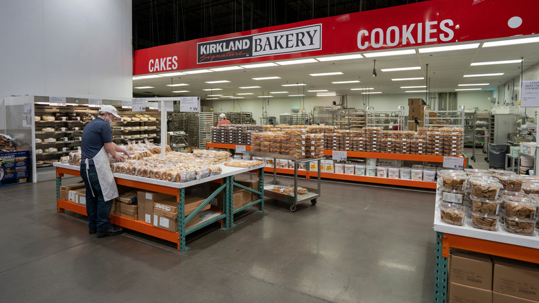 Costco bakery section with employee putting out baked goods
