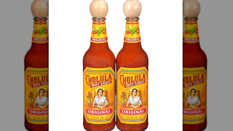 Two bottles of Cholula hot suace against a white background.