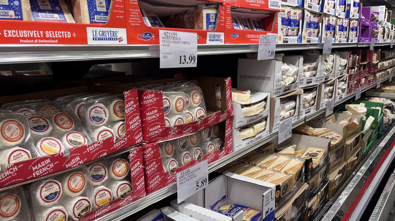 An assortment of packaged cheeses in a Costco cold case