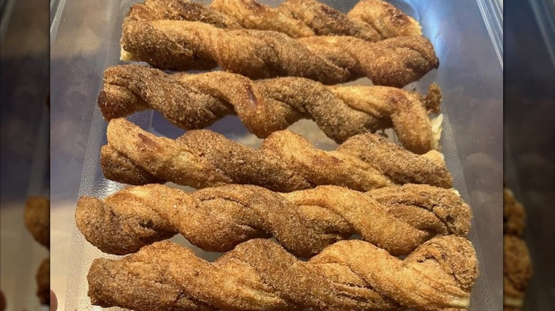Several Costco churros lined up in a plastic container