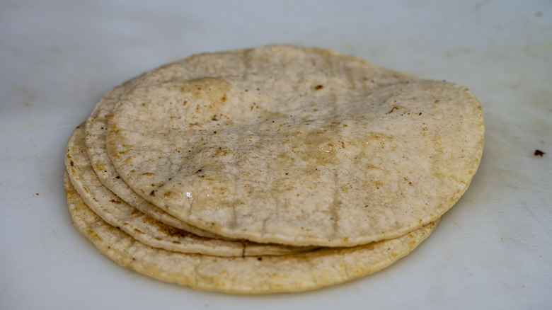 Pile of corn tortillas on a cutting board