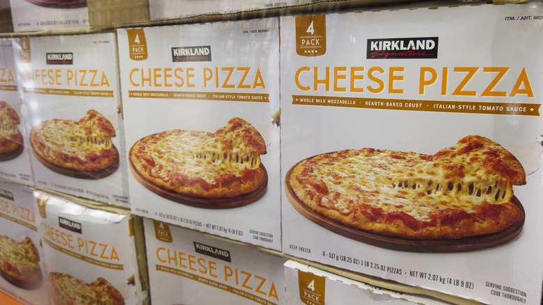 Boxes of Kirkland Signature Cheese Pizza lined up in the freezer section