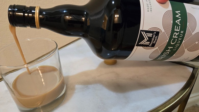 Pouring Member's Mark Irish Cream in a glass
