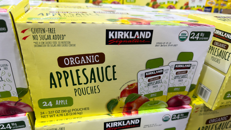 Cardboard boxes stacked atop one another, each with 24 applesauce pouches