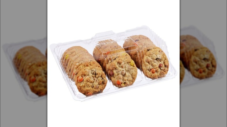 Plastic tray of Kirkland Signature Peanut Butter Monster Cookies on white background