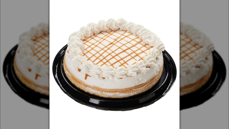 Whole Kirkland Signature Salted Caramel Cheesecake on plastic tray on white background
