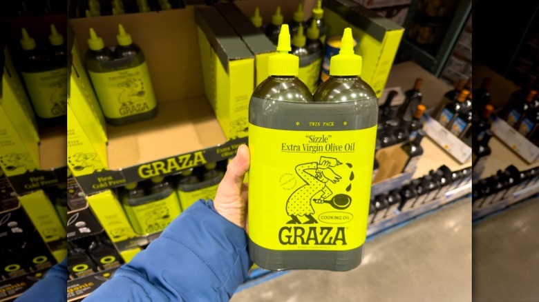 Someone holds up a packet of Graza Olive Oil at Costco