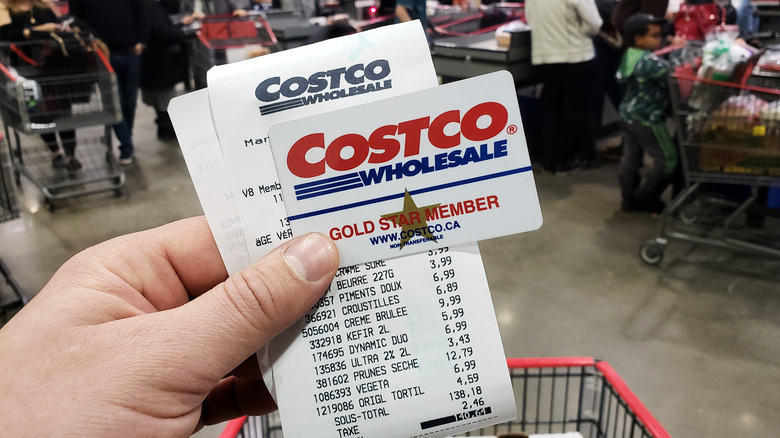 Costco membership card and receipt in hand while shopping