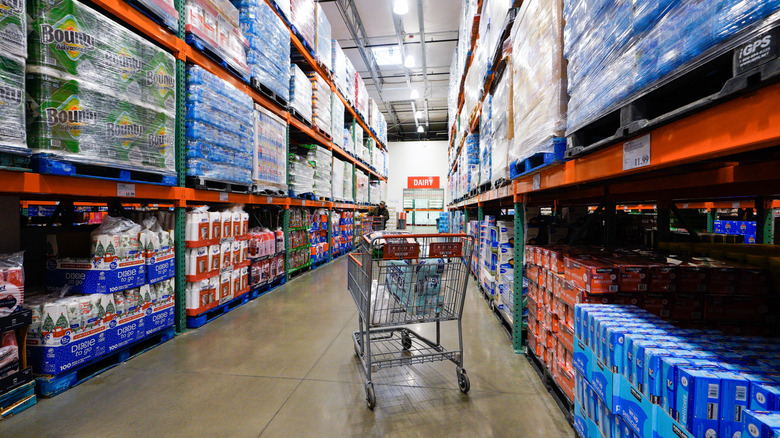 Aisle of Costco with grocery cart in the middle
