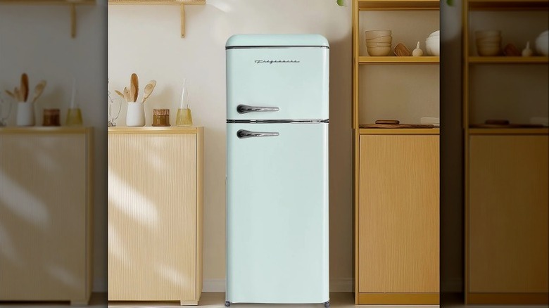 A light teal, retro Frigidaire mini fridge and freezer in a small sized kitchen.