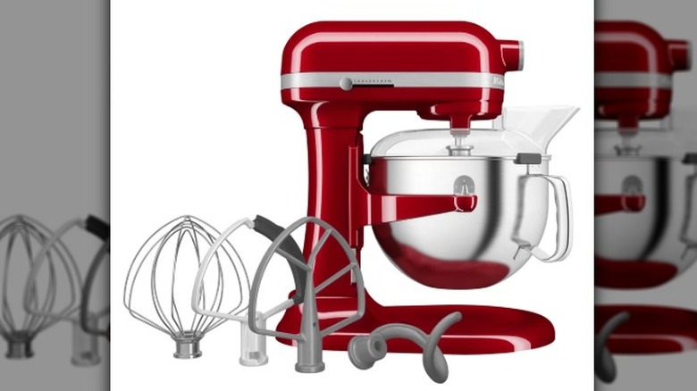 A red KitchenAid mixer with multiple attachments on a white background.