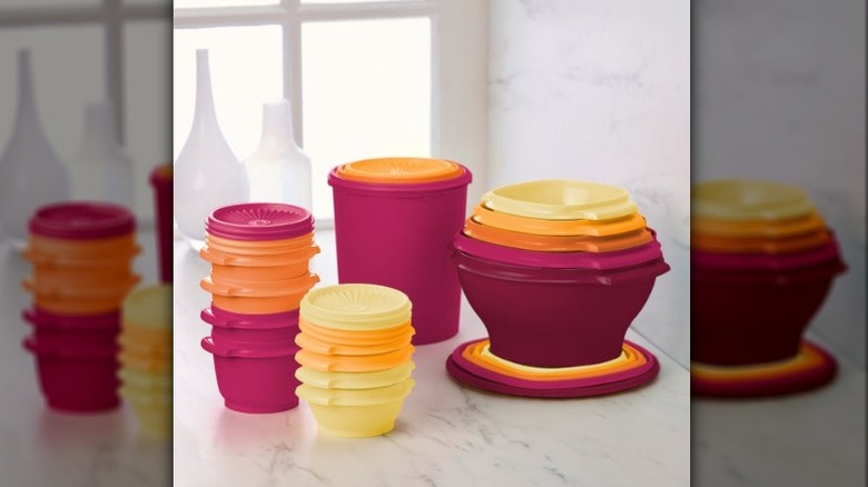 A 32-piece Tupperware Heritage collection of colorful jars and bowls of various sizes on a neutral marble.