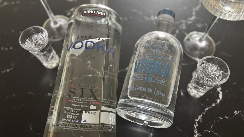 Costco Kirkland American vodka bottle next to Trader Joe's small batch vodka bottle with shots and coupe glasses