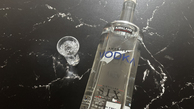 Shot of vodka next to Kirkland American vodka bottle