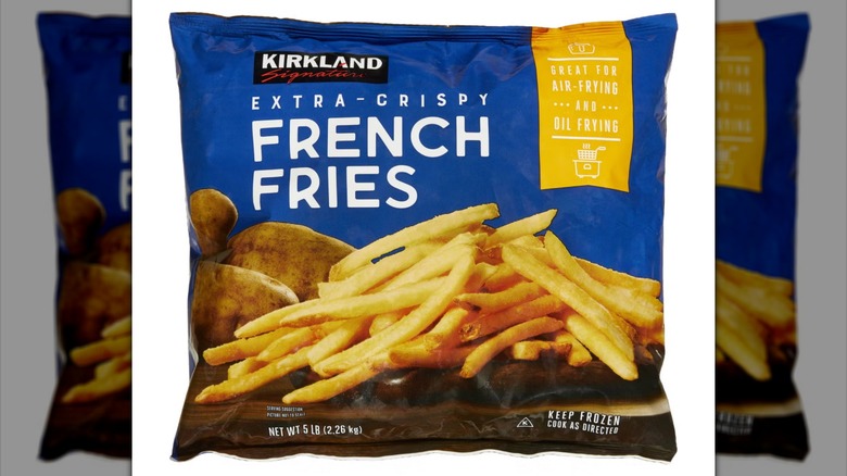 Blue bag of Kirkland Signature Extra Crispy French Fries on white background