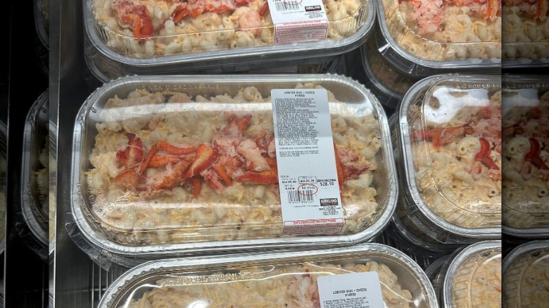 Trays of Costco macaroni and cheese topped with lobster claw meat