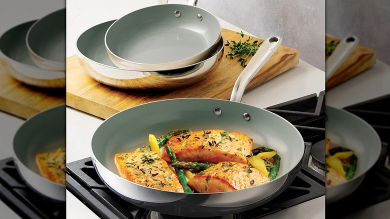 Tramontina Stainless Steel Ceramic Nonstick Fry pan on stovetop next to two other pans on wooden cutting board