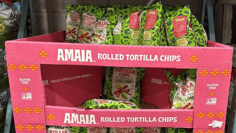 A pink display box of AMAIA Chili Lime Rolled Tortilla Chips at a Costco warehouse