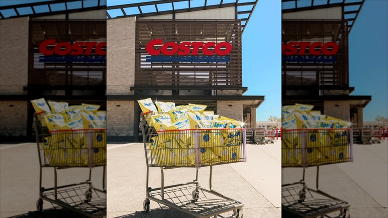 A cart full of bags of Khloud White Cheddar Protein Popcorn outside of a Costco warehouse