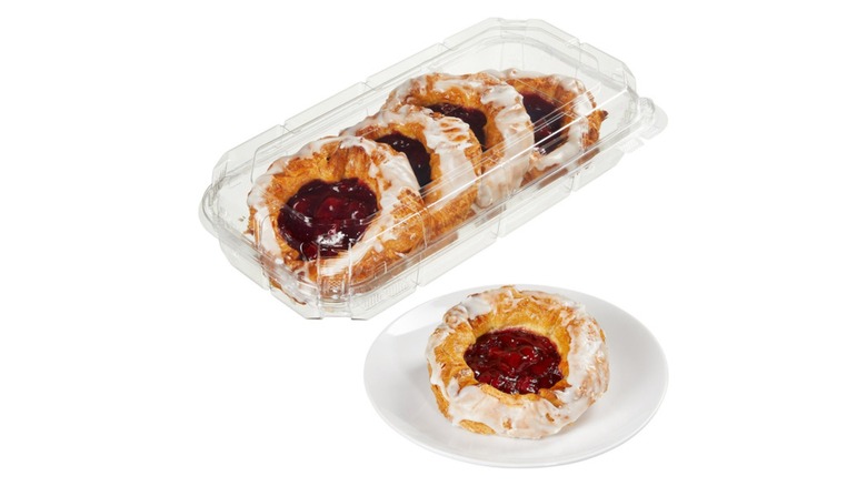 A beauty shot of a 4-pack, and one on a plate, Kirkland Signature cherry danish on a white background