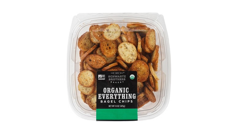 A beauty shot of Schwartz Brothers Bakery Organic Everything Bagel Chips in plastic tub on white background