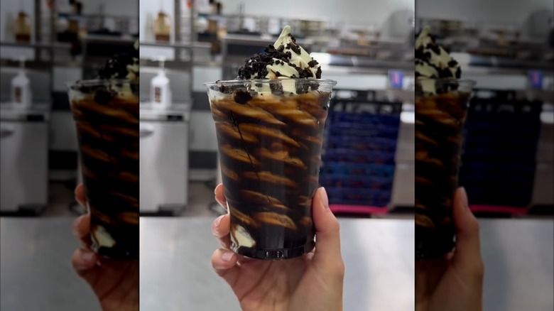 Hand holding Vanilla Cookie Crunch Sundae from Costco