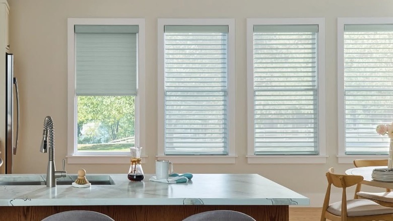 A kitchen with a marble countertop and white blinds