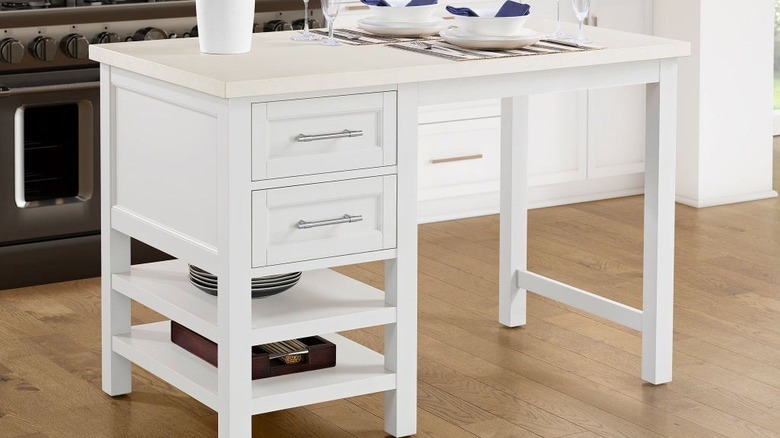 A white kitchen island with drawers and shelves