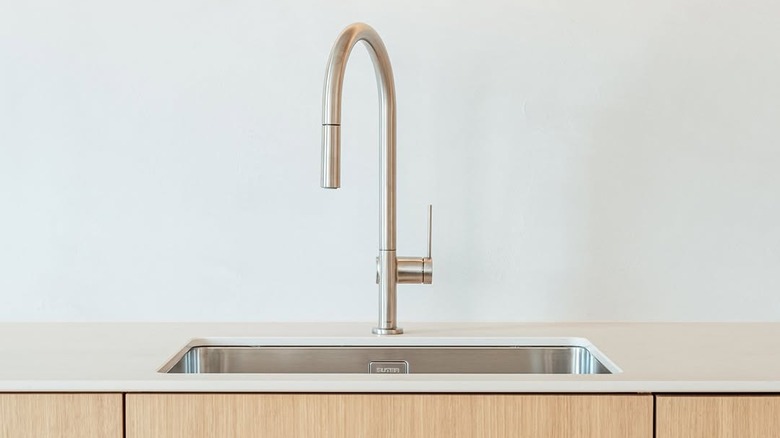 A Hansgrohe kitchen faucet above wooden cabinets
