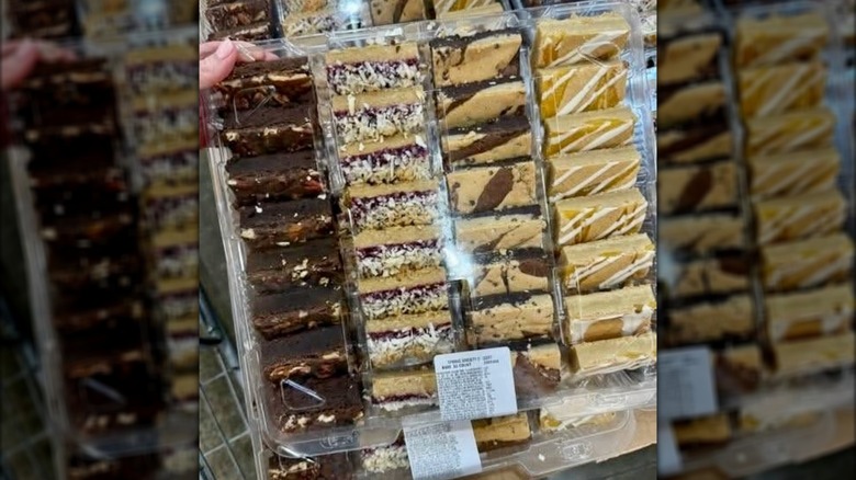 Hand holding tray of Costco bars, including the Lemon Blondie Dessert Bars